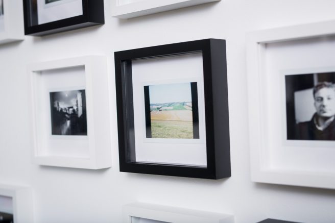 Polaroid-Wand mit Bilderrahmen im Schachbrettmuster.